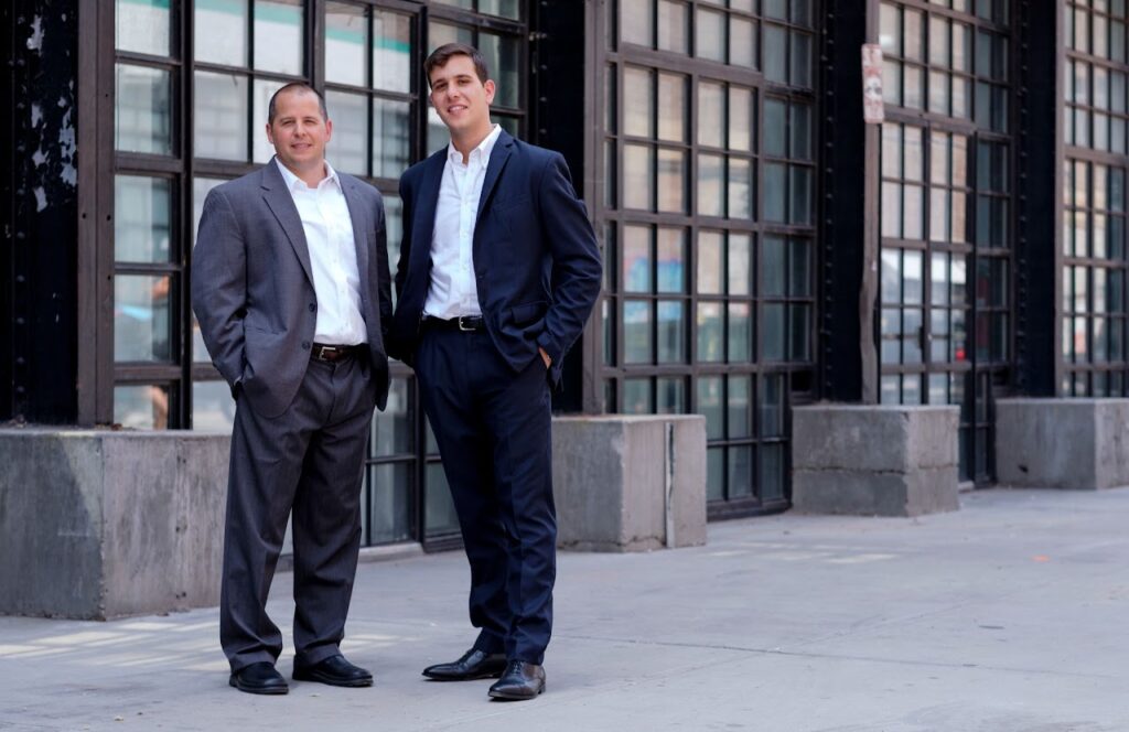 Commercial Real Estate Brokerage Experts, Josh and Andrew, standing confidently in front of a prime commercial property in Greenpoint